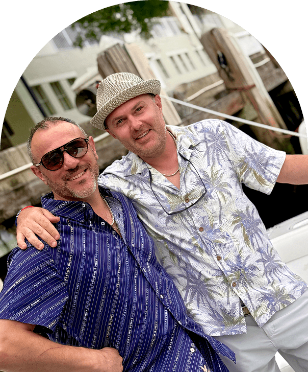 Two men smiling in tropical shirts.