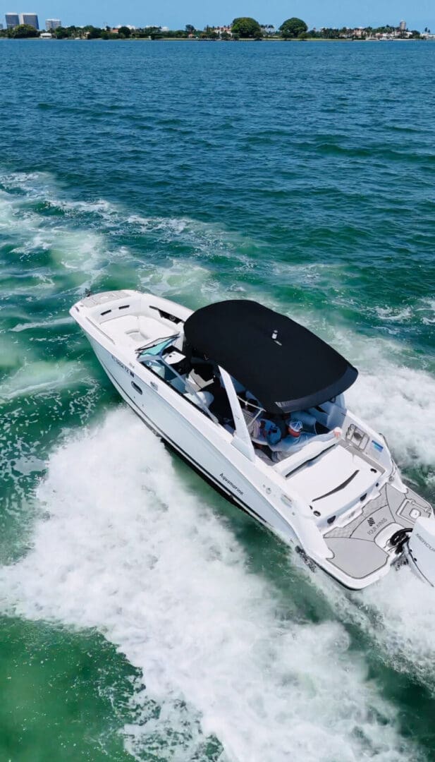 White motorboat cruising on blue ocean water.