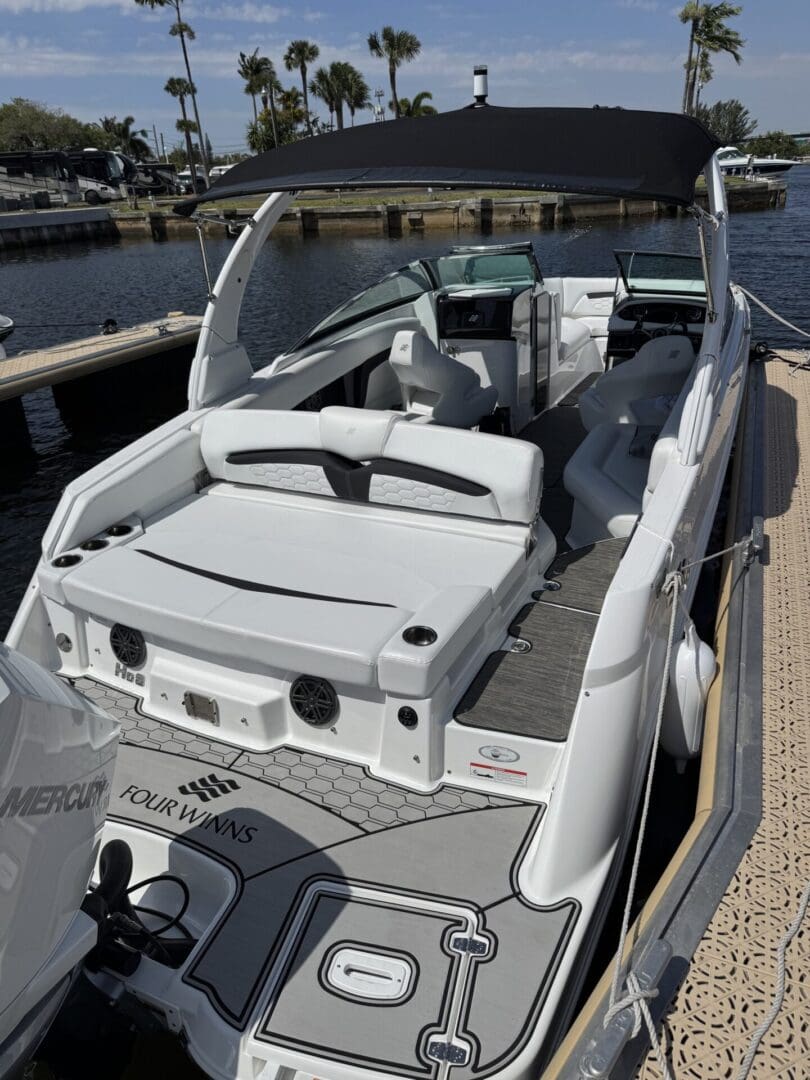 Luxury motorboat docked at marina, sunny day.