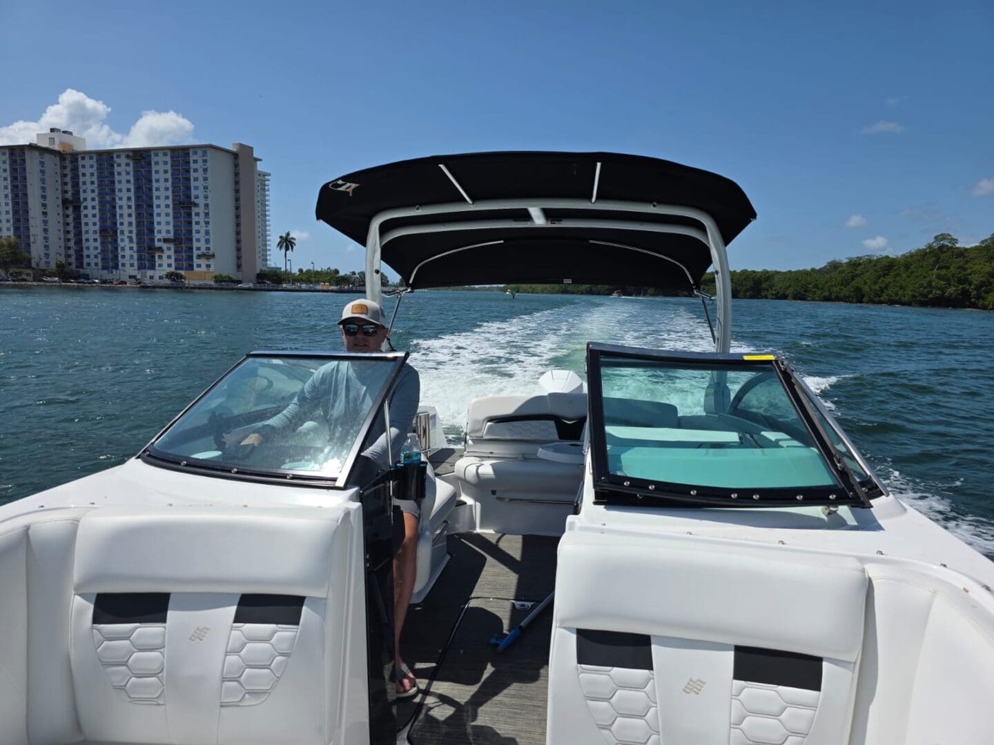 Person driving boat on sunny day.